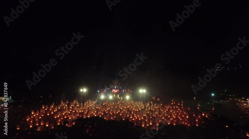 Drone shot of thousand sky lanterns launching to the sky with black foreground of the tree in 4k 60fps