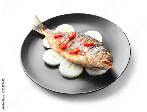 Plate with grilled dorado fish and vegetables on white background