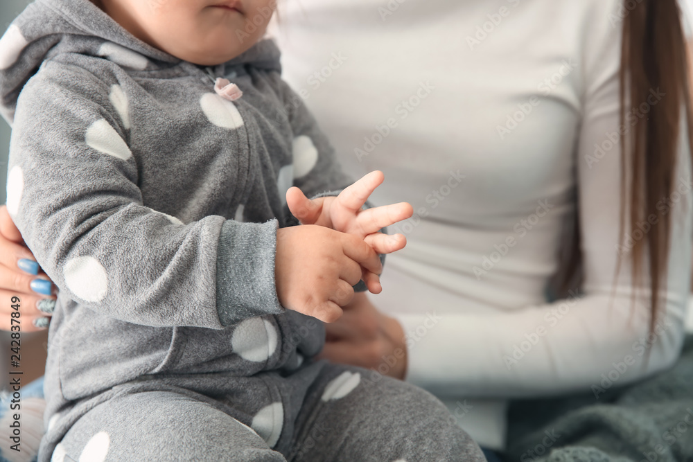 Fototapeta premium Cute baby girl with mother at home, closeup
