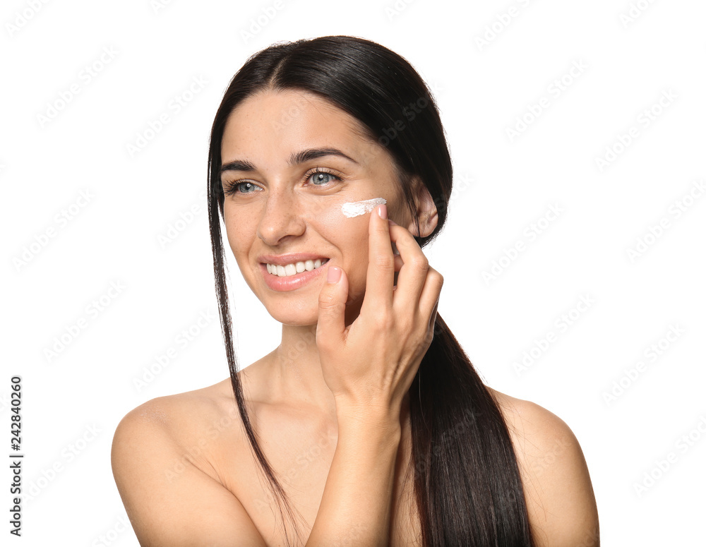 Portrait of beautiful young woman applying facial cream on white background Portrait of beautiful young woman applying facial cream on white background