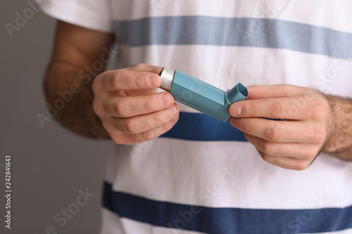 Man holding asthma inhaler ...