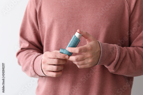 Young man with inhaler on w...