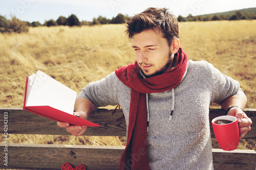 Handsome man reading a book in his holidays photo