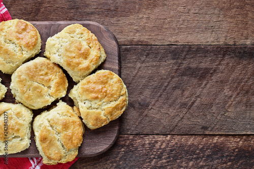 Murais de parede Fresh buttermilk southern biscuits or scones over a rustic wooden table shot from above