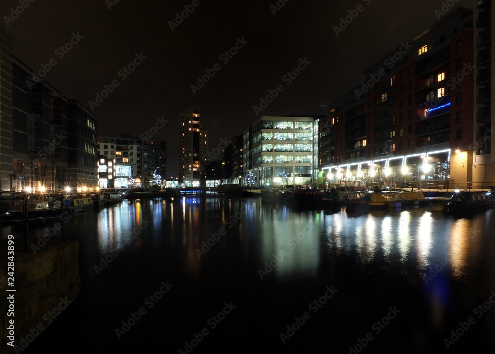a view of clarence dock in leeds at night with waterside buildings and lights reflected in the water