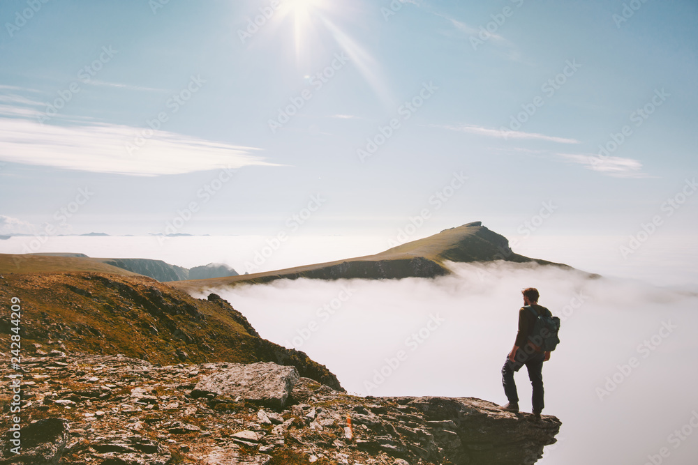 Traveler man hiking alone in mountains over clouds enjoying view active summer vacations trip adventure travel lifestyle outdoor