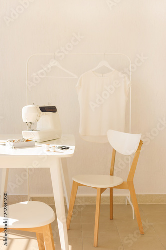 Workplace for sewing and needlework in a bright room with white furniture. © COLOR PHOTO
