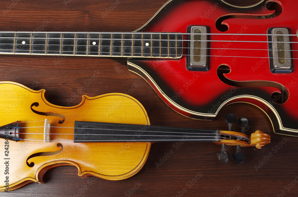 Fototapeta premium Guitar and violin on a wooden table