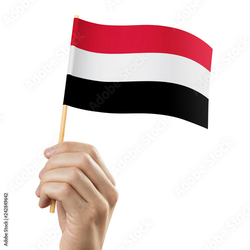 Hand holding flag of Yemen, isolated on white background photo