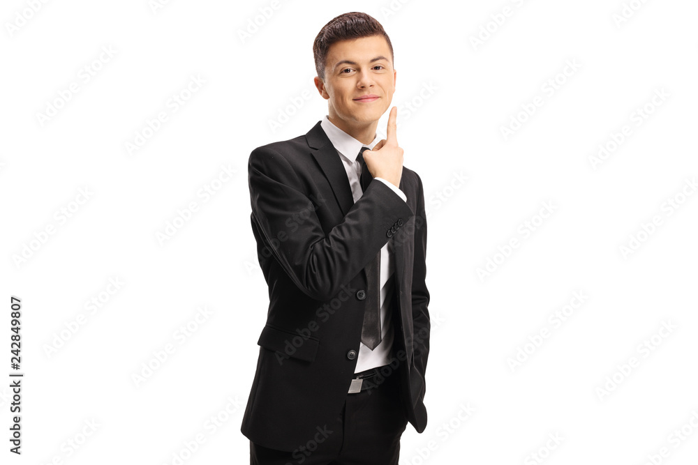 Young man in a suit pointing to his cheek and waiting for a kiss Young man in a suit pointing to his cheek and waiting for a kiss