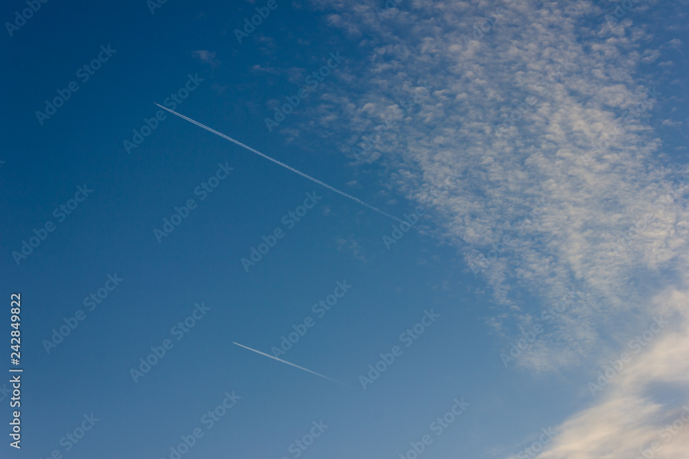 jet contrails on blue sky sunset at south german countryside