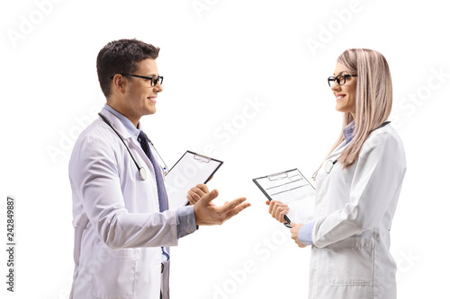 Male doctor with a clipboard talking to a female doctor