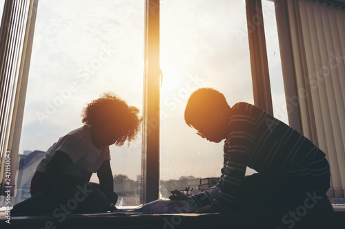 Silhouette picture,Children sit near window side and draw picture at library,fun and happy,education concept,learning and knowledge image.