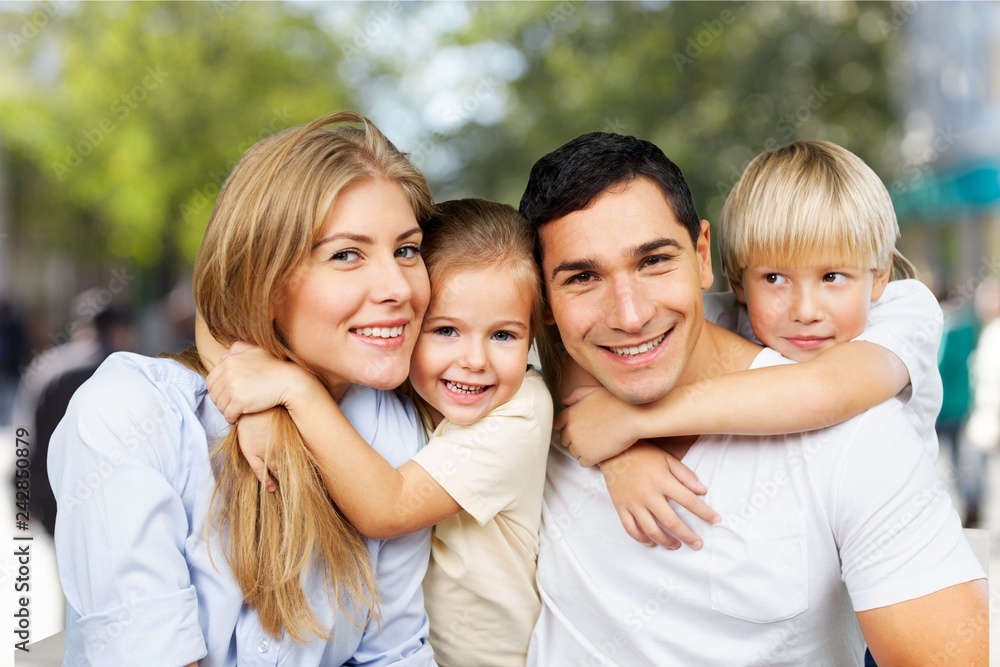 Happy smiling family with daughter over green trees background Happy smiling family with daughter over green trees background