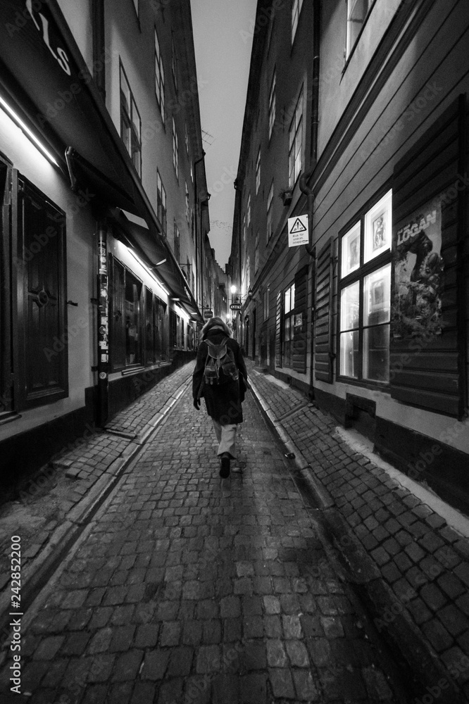 woman alone at night in old town of Gamla Stan, Stockholm, Sweden woman alone at night in old town of Gamla Stan, Stockholm, Sweden