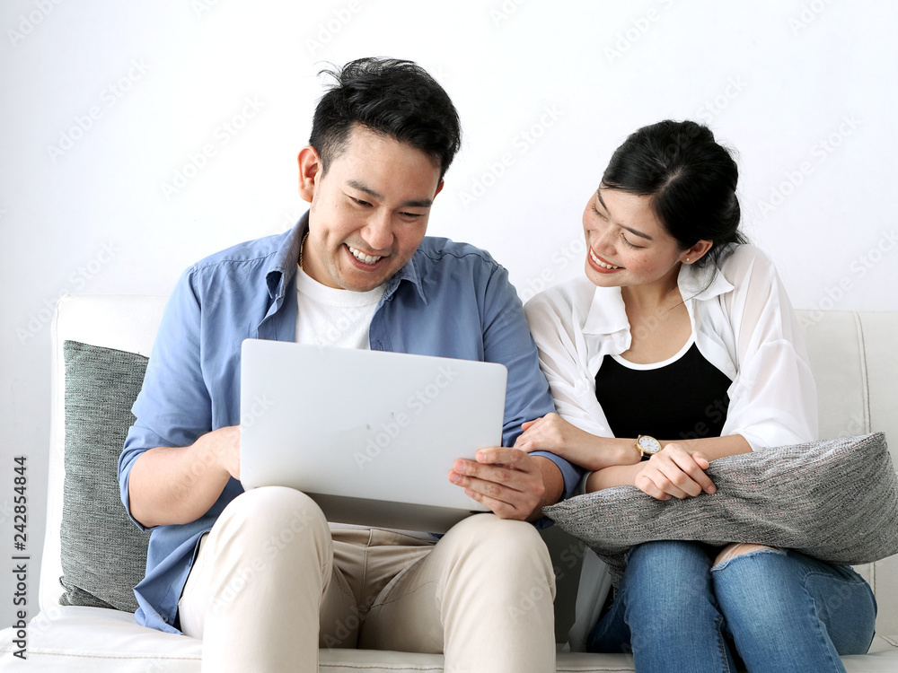 Happy Asian couple using laptop at home, lifestyle concept. Happy Asian couple using laptop at home, lifestyle concept.