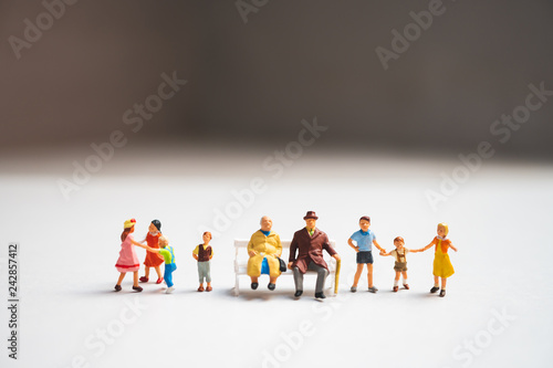 Miniature grandparents standing with children using as family concept