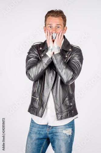 portrait of young man in black eather jacket isolated on a white background. Emotion and people concept. photo