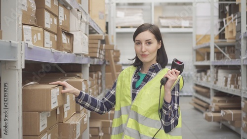 Portrait store worker using bar code scanner scanning labels on boxes photo