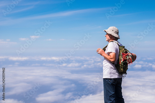 Old silver societ white hair man standing and resting looking the blue sky infinite in front of him and enjoying the trekking travel - freedom third age concept for youth people inside photo