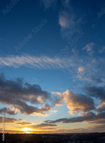 Sunset over town with blue sky and clouds