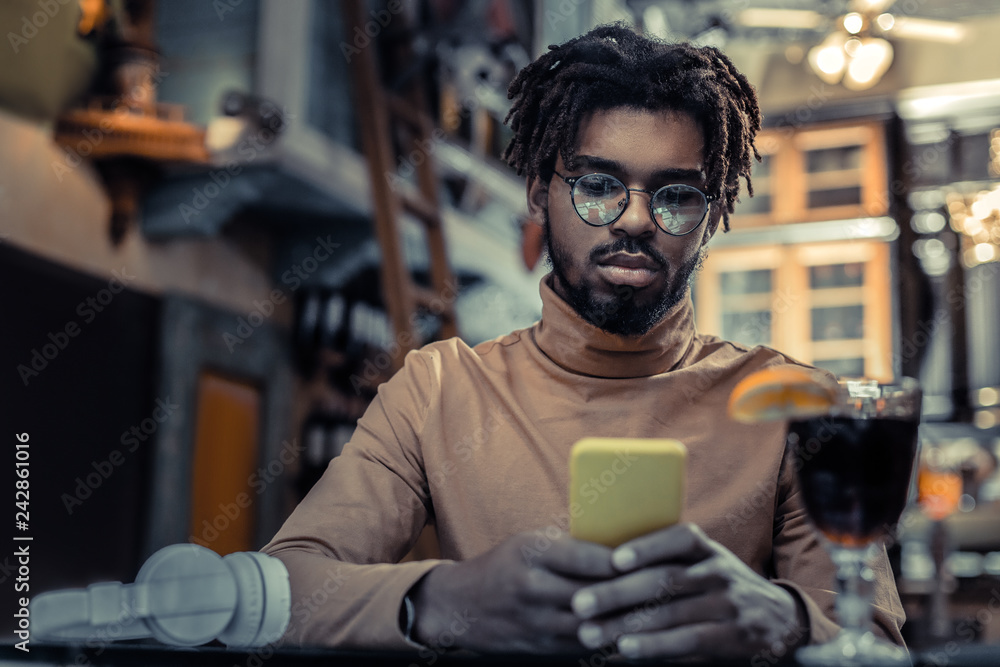 Attentive brunette male person using his gadget