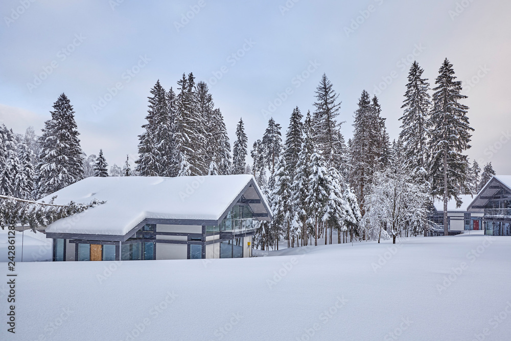 Wooden Finnish house in winter forest covered with snow Wooden Finnish house in winter forest covered with snow