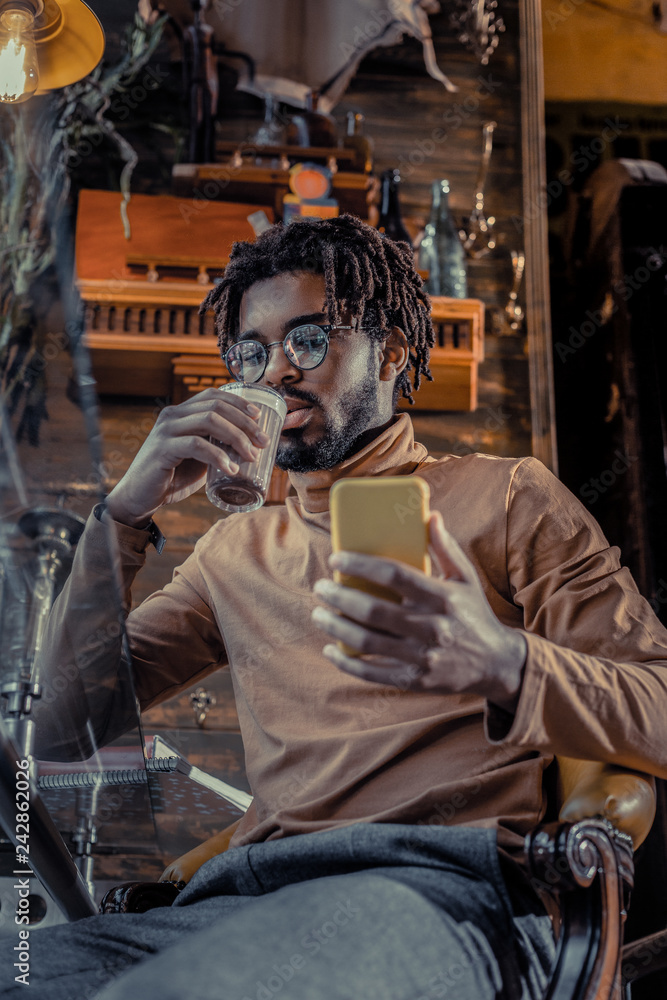 Obraz premium Handsome bearded freelancer drinking cacao in cafe