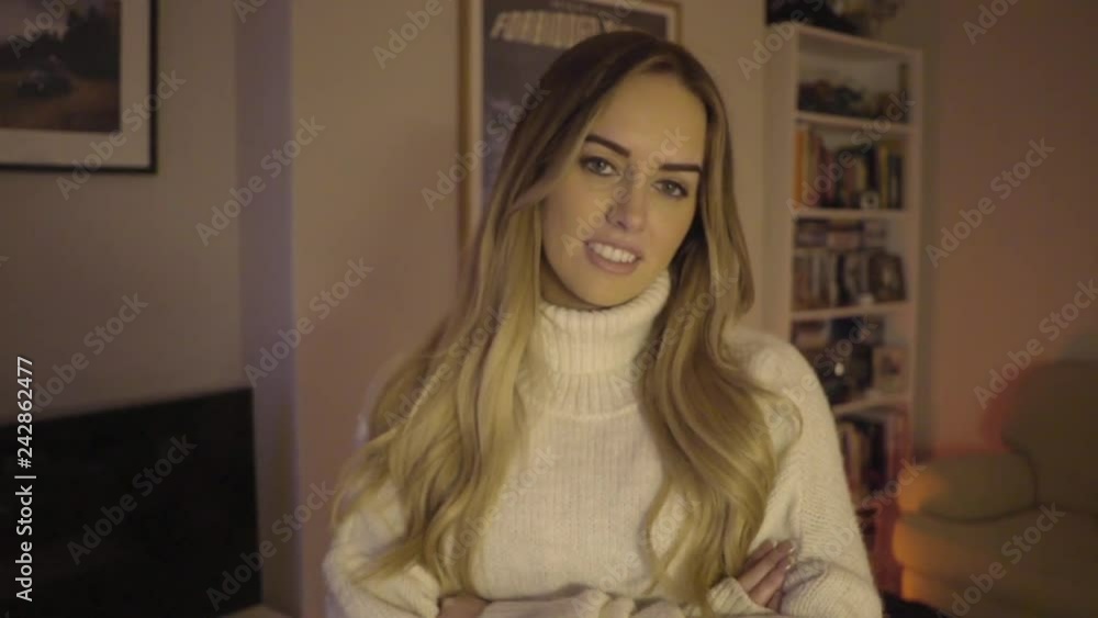 confident woman smiles at camera in her apartment living room home owner confident woman smiles at camera in her apartment living room home owner
