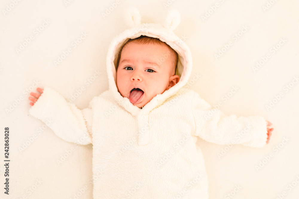 Newborn baby girl posed and playing with her tongue to talk, looking at camera Newborn baby girl posed and playing with her tongue to talk, looking at camera
