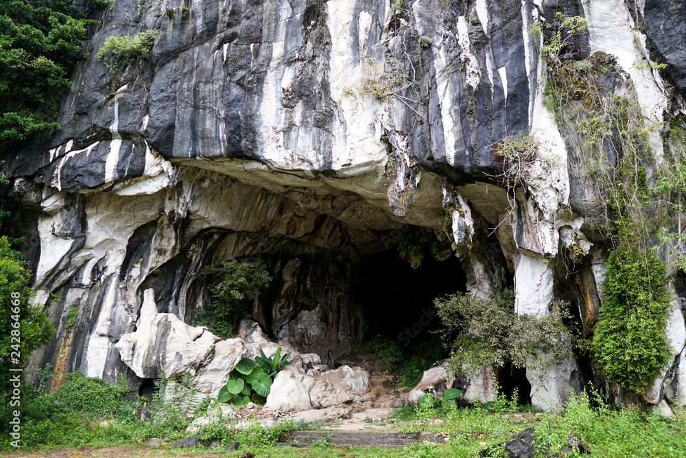 Beautiful natural limestone cave entrance in Malaysia. Limestone Hill and Cave.Jungle covered and dramatic rounded hill and huge hollow feature. - Image           