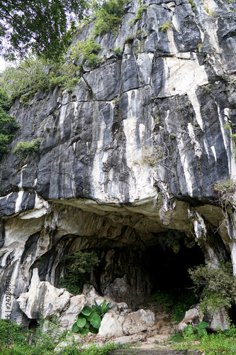 Beautiful natural limestone cave entrance in Malaysia. Limestone Hill and Cave.Jungle covered and dramatic rounded hill and huge hollow feature. - Image 
