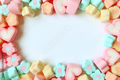 Top View of Many Pastel Color Flower Shaped and Heart Shaped Marshmallow Candies with Free Space for Text and Design 