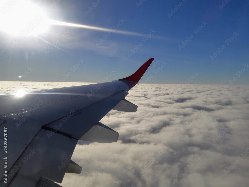 Fototapeta premium wing of an airplane flying above clouds
