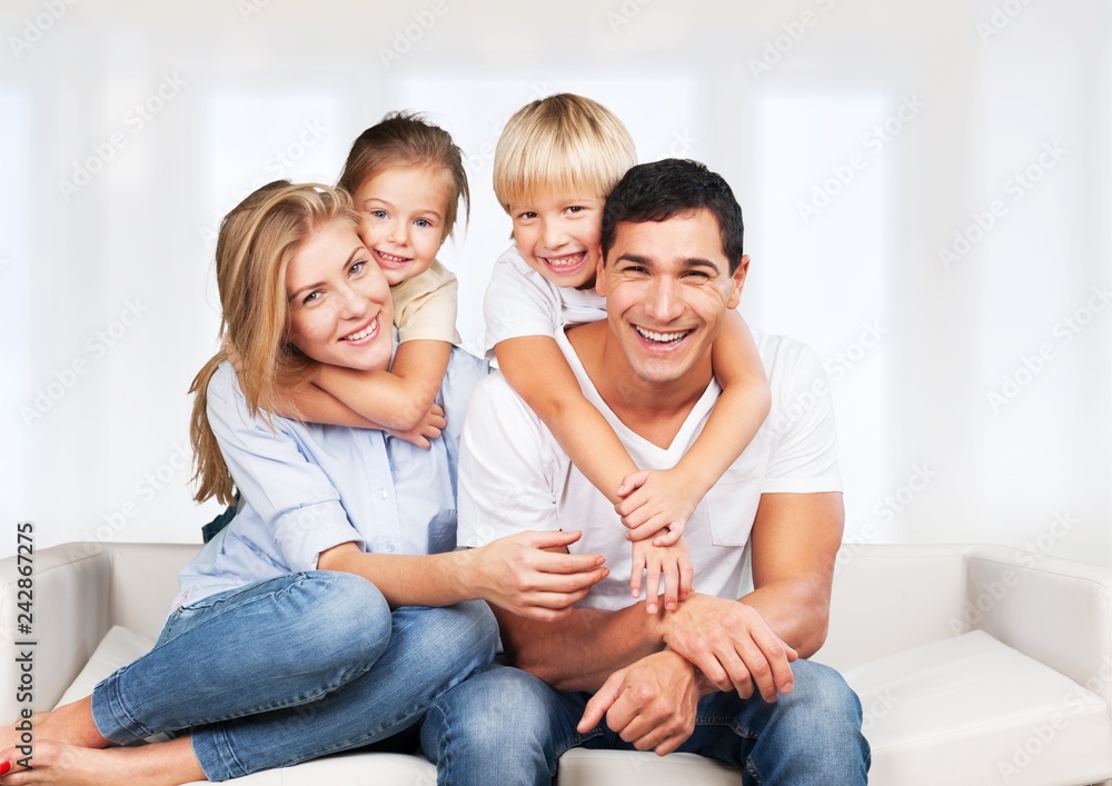 Beautiful smiling family sitting at sofa at home