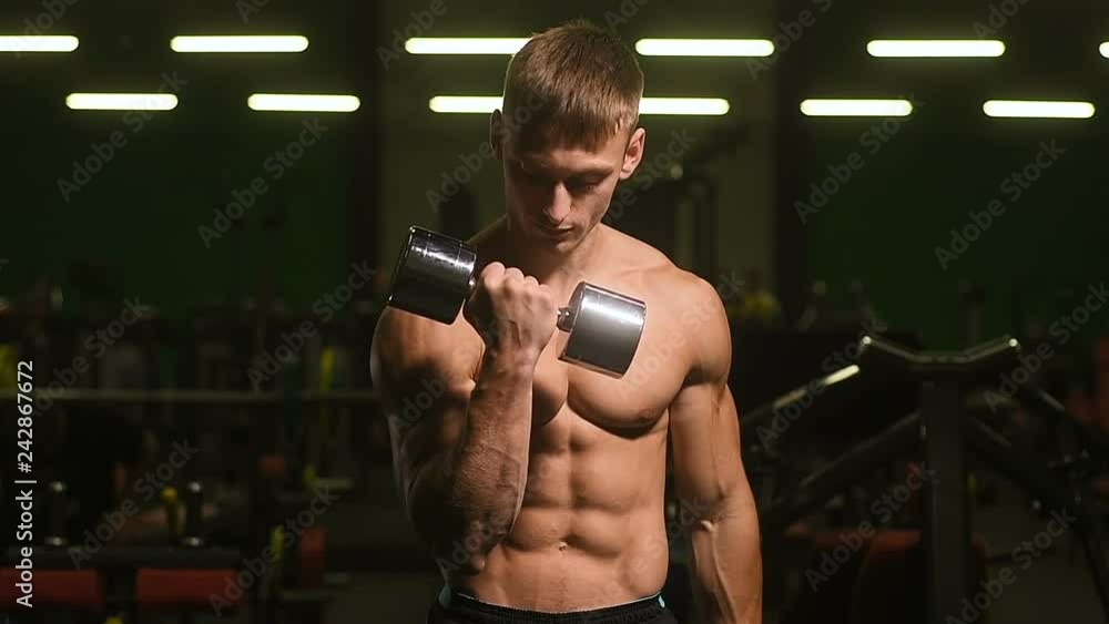 Handsome strong athletic men pumping up biceps muscles workout fitness and bodybuilding concept background - muscular bodybuilder fitness men doing arms exercises in gym naked torso slow motion 
