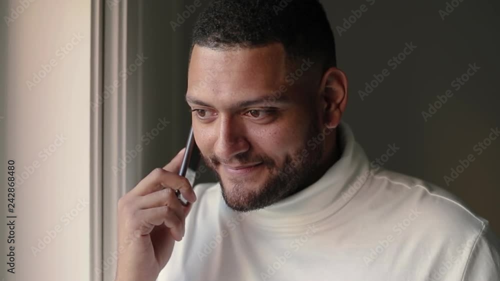 Cheerful mix raced guy phoning girlfriend. Closeup of young man dialing number and talking on cell, nodding and smiling. Friendly phone talk concept Cheerful mix raced guy phoning girlfriend. Closeup of young man dialing number and talking on cell, nodding and smiling. Friendly phone talk concept