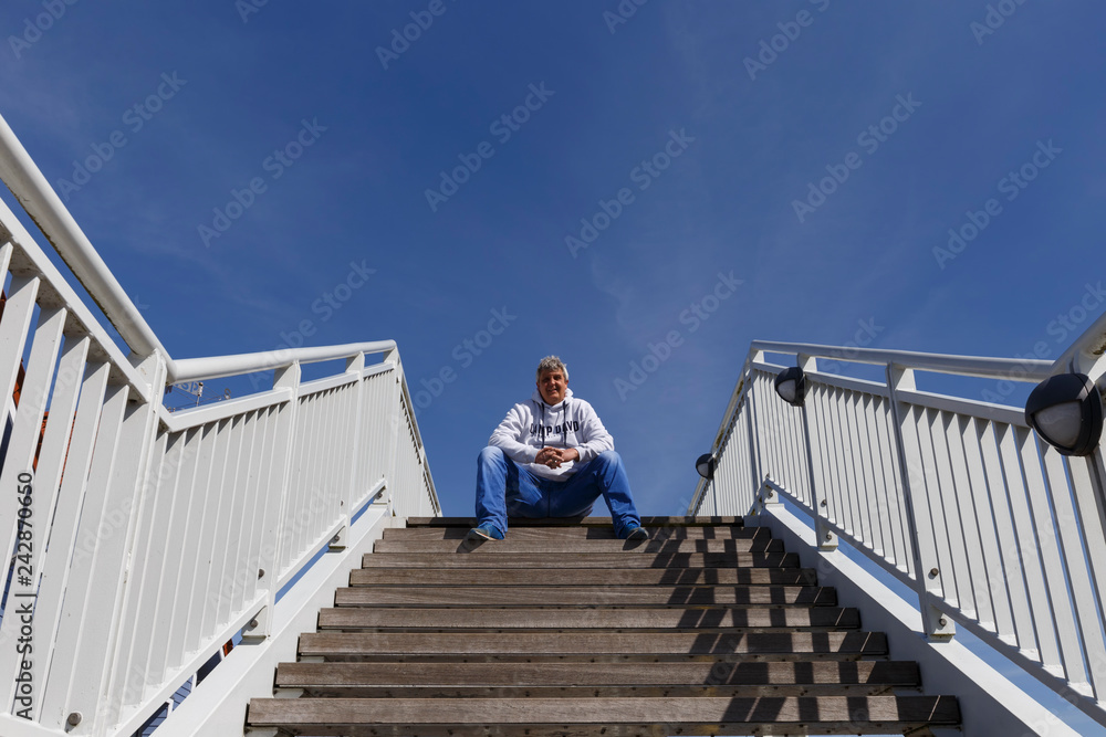 Mann sitzt auf Treppe und lacht