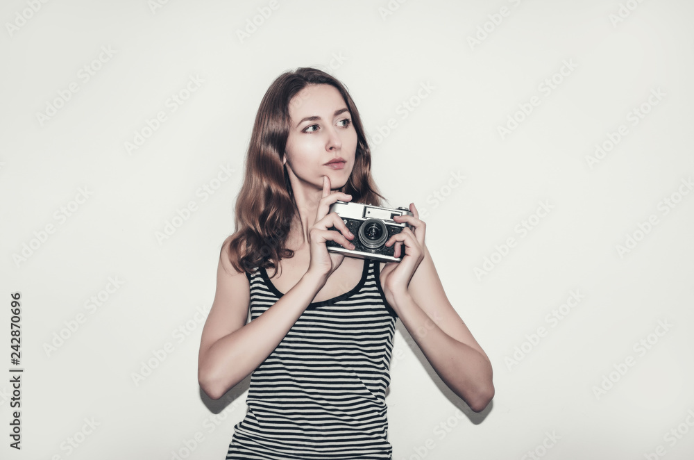 Nice girl in a striped t-shirt with a vintage camera in her hands. Photographing people. Nice girl in a striped t-shirt with a vintage camera in her hands. Photographing people.
