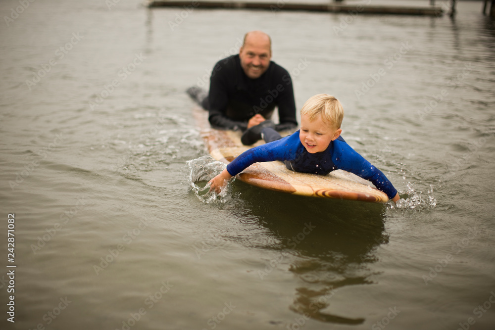 Father and son lying on surfboard. Father and son lying on surfboard.