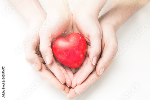 Man and woman holding red heart in hands isolated