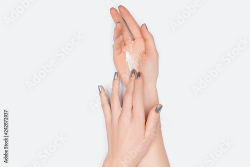 cropped view of woman applying hand cream isolated on white
