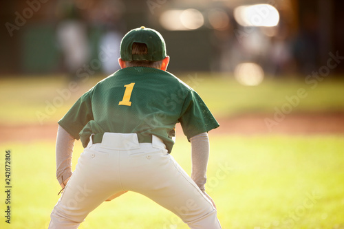 Baseball player crouches while fielding during a baseball game.