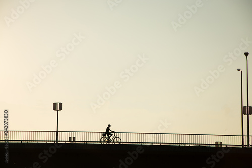 Canvas Print silhouette bicycle of bicycle rider on the bridge against sunset, minimalistic u