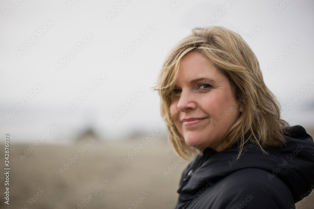 Woman standing on beach looking at the camera Woman standing on beach looking at the camera