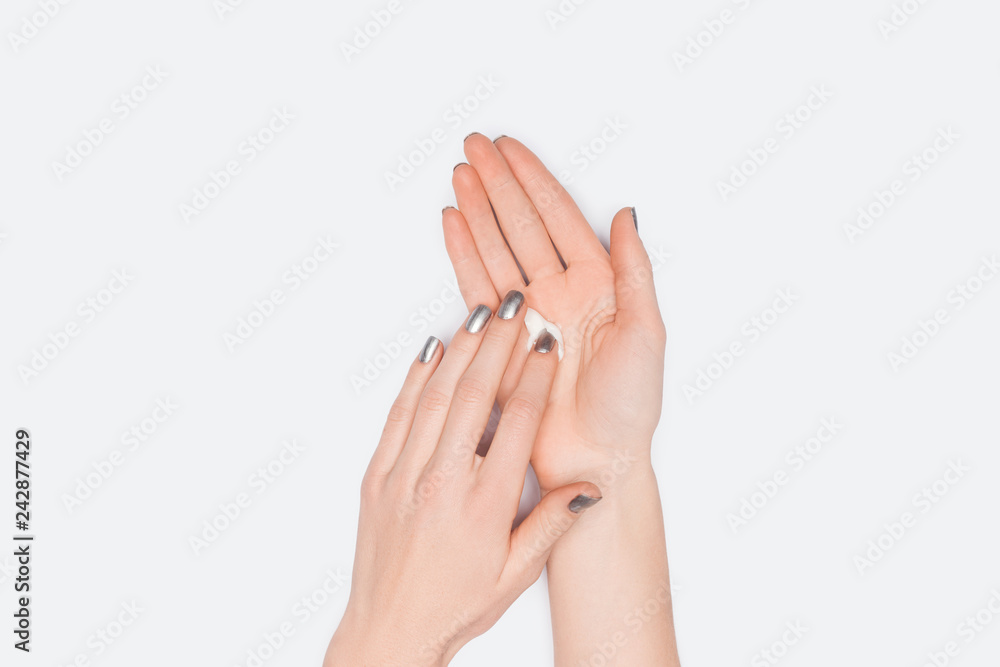 partial view of woman applying hand cream isolated on white partial view of woman applying hand cream isolated on white