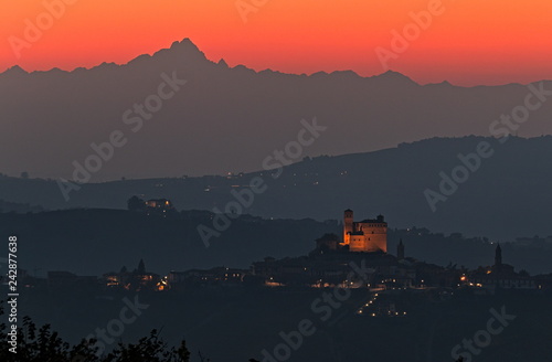 Monviso and Serralunga d'Alba castle silhouette during sunset with bright red sky