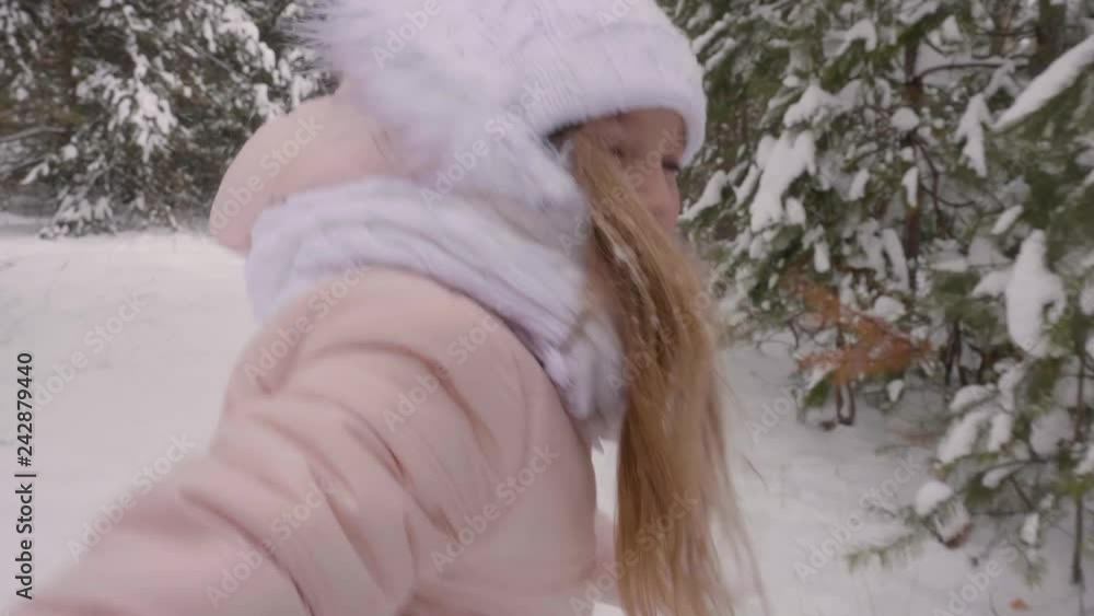 Happy girl hand leading through snowy path way. Playful caucasian adorable girl running in winter woods, among snowy pine trees. Slow Motion forest park winter Happy girl hand leading through snowy path way. Playful caucasian adorable girl running in winter woods, among snowy pine trees. Slow Motion forest park winter