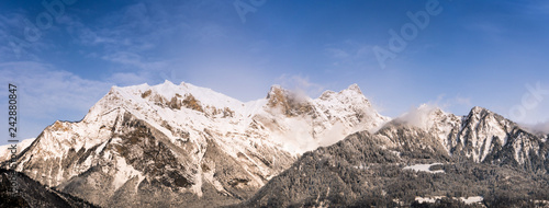 winter mountain landscape with snowy jagged peaks under a blue sky photo