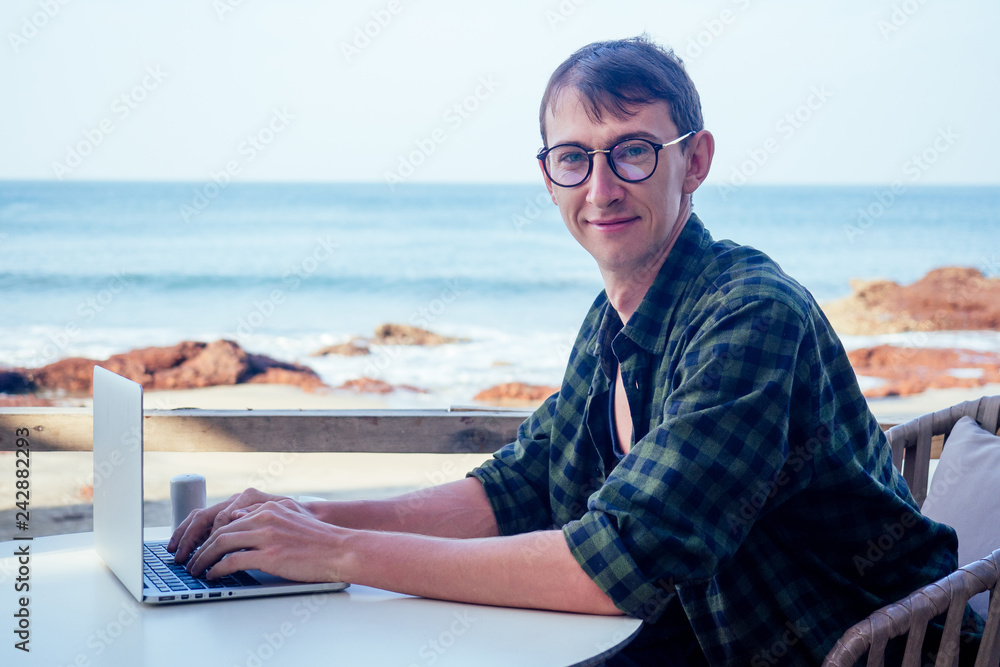 Funny business man geek using laptop on tropical vacation